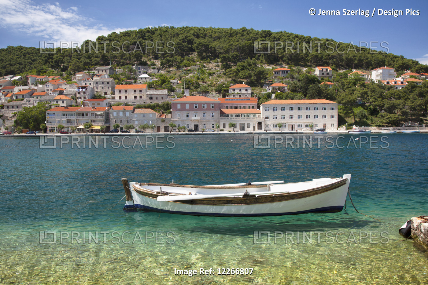 A Small Boat Rests In The Tranquil Clear Water; Pucisca, Island Of Brac, Croatia