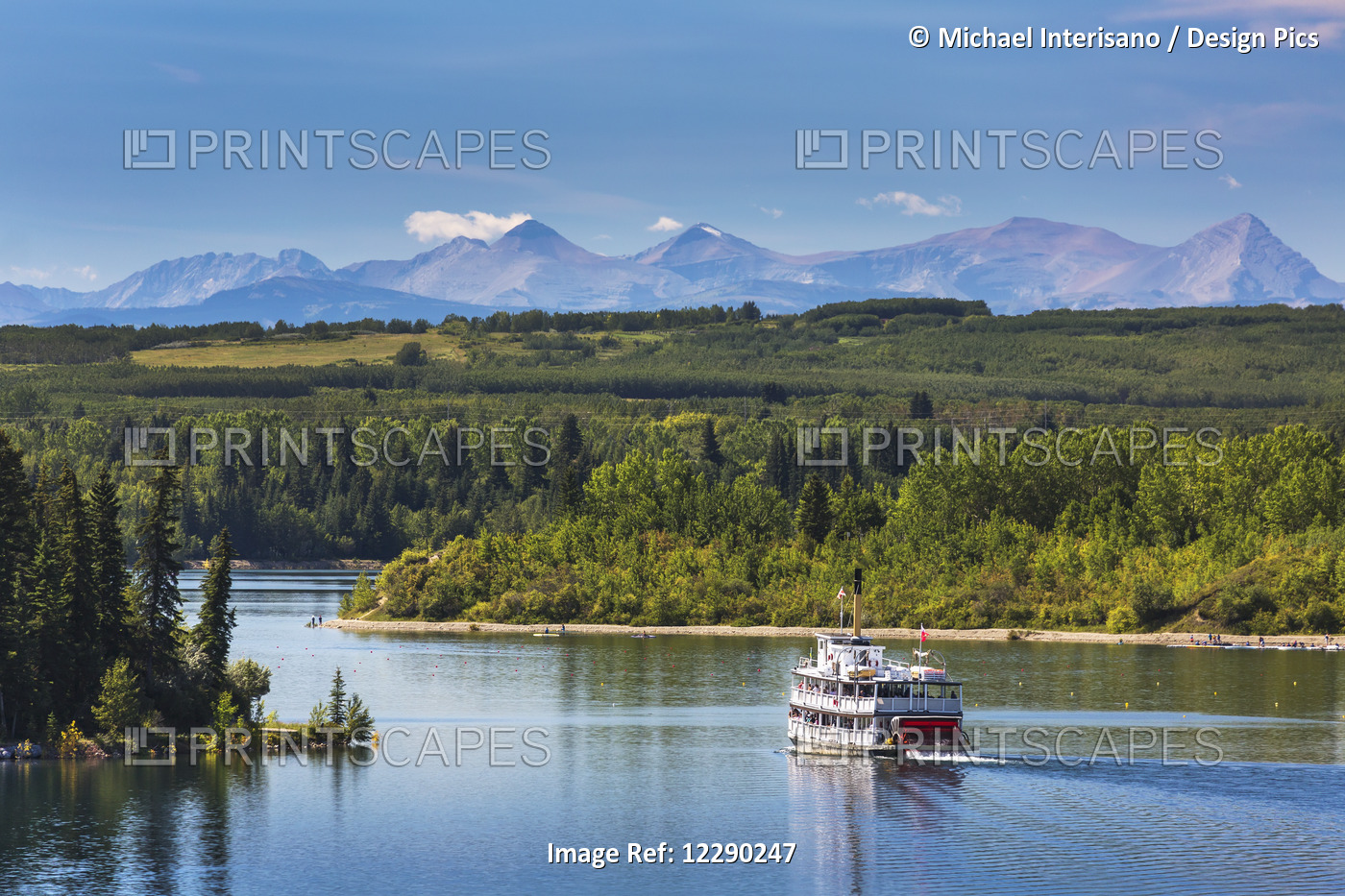 Paddlewheel Boat On Lake With Tree Lined Shoreline, Hills And Mountains In The ...