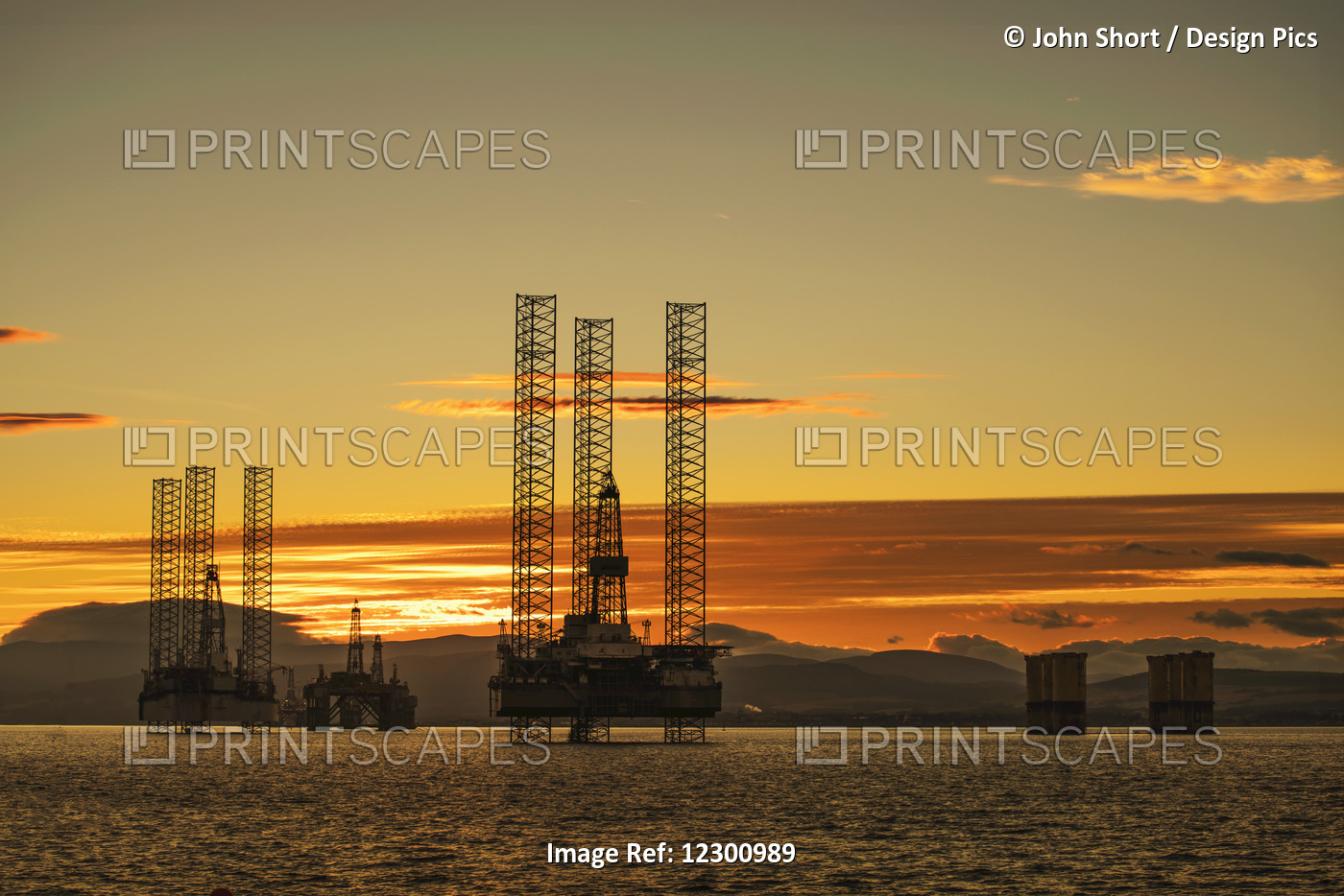 Oil Drilling Rigs Out In The Ocean With A View Of The Coastline And Golden ...