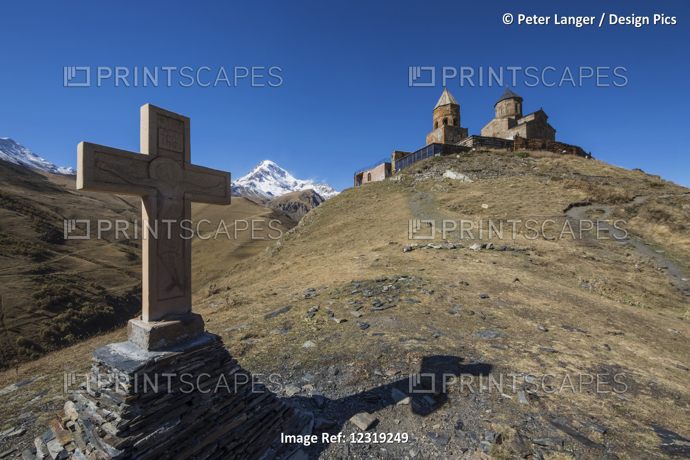 Stone Cross And Gergeti Trinity Church With Mount Kazbek In The Background; ...