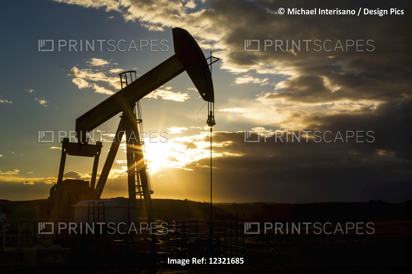 Silhouette Of Pump Jack With Dramatic Storm Clouds, Blue Sky And Sunburst; ...