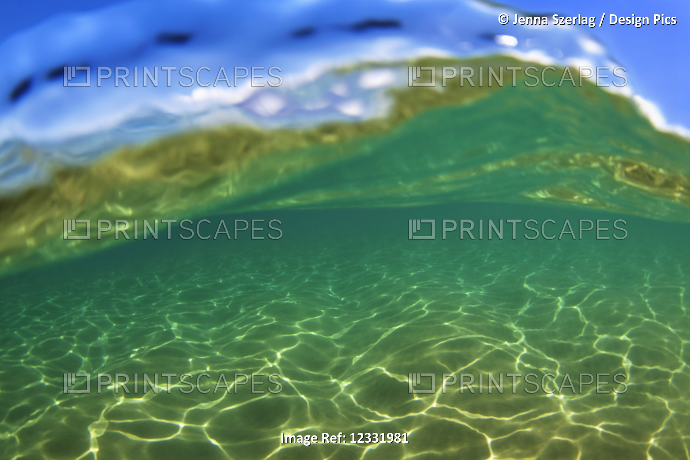 Split view of the blue sky, ocean surface and underwater; Maui, Hawaii, United ...