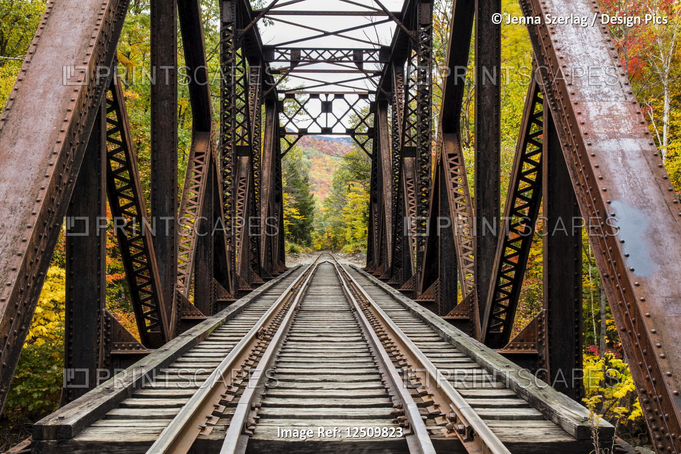 Iron railroad bridge over Sawyer River with trees in autumn colours, White ...